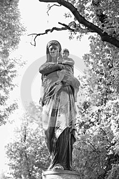 Silver statue of the Virgin Mary with the baby Jesus Christ in h