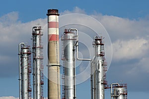 Silver steel and concrete chimney of oil refinery