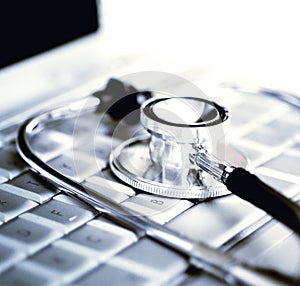 Silver stethoscope over laptop keyboard