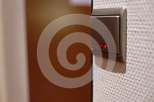 Silver switch with indicator on white wall