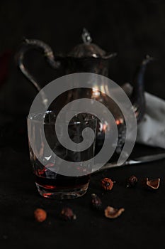 Silver teapot and dried rosehips