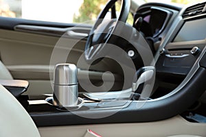 Silver thermos in holder inside of car photo