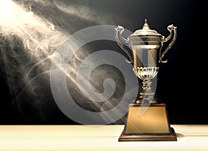 silver trophy placed on wooden table with dark background copy s