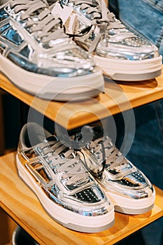 silver unisex sneakers shoes on shelf display in shop mall store. Store Of Shopping Center. retail sale