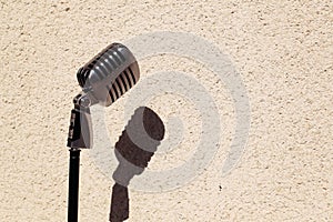Silver vintage microphone in the studio on wall background
