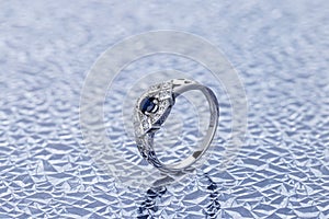 Silver wedding ring decorated with sapphire and diamonds