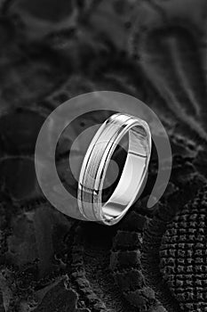 Silver wedding ring with with glossy and matte surface on black background