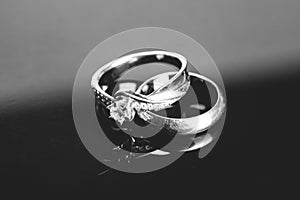 silver wedding rings, diamond ring on black background