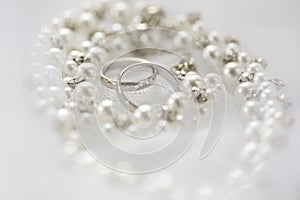 Silver wedding rings and pearl necklace