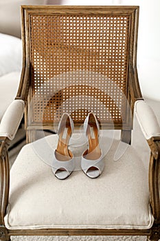 Silver wedding shoes on a beige chair