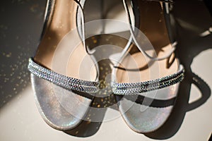 Silver wedding shoes stand on the table