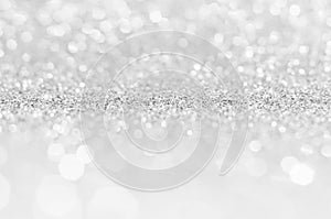 Silver white abstract light grey background, shining lights, sparkling glittering Christmas lights. Blurred abstract holiday backg