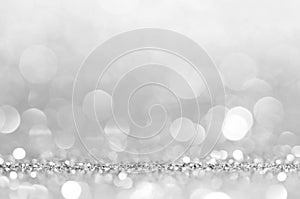 Silver white abstract light grey background, shining lights, sparkling glittering Christmas lights. Blurred abstract holiday backg