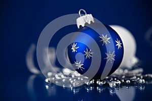 Silver, white and blue christmas ornaments on dark blue background. Merry christmas card.