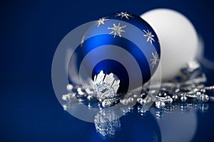 Silver, white and blue christmas ornaments on dark blue background. Merry christmas card.