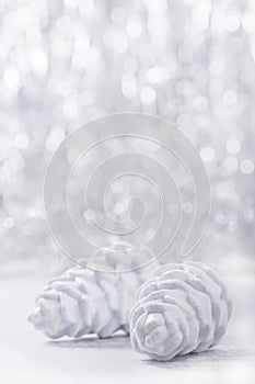 Silver and white Christmas ornaments on glitter bokeh background with space for text. Xmas and Happy New Year
