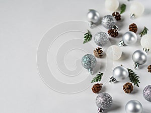 Silver and white gliter Christmas ball, cones and Christmas tree branch border flat lay. Copy space