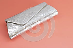 Silver women clutch for evening outings. Clutch bag on a pink background, place for text, copy space