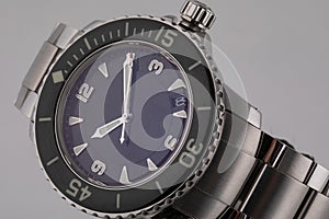 Silver wristwatch with blue dial, silver clockwise, chronograph, on metal strap on white background