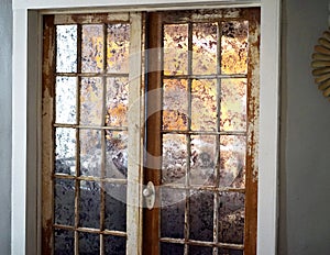 Silvered French door windows are opaque and reflect light