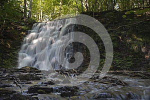 Silverfallet Staircase Waterfall illuminated by low rays of sun