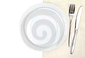 Silverware or flatware set of fork, knife and plate on towel