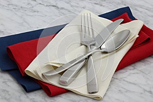 Silverware and hemstitch napkin on antique carrara marble