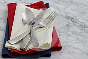 Silverware and hemstitch napkin on antique carrara marble