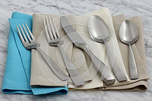 Silverware and hemstitch napkin on antique carrara marble