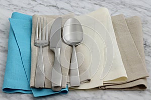 Silverware and hemstitch napkin on antique carrara marble