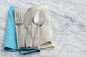 Silverware and hemstitch napkin on antique carrara marble