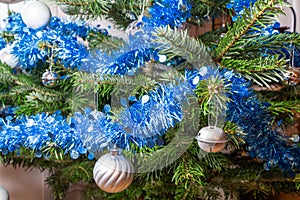 Silvery Christmas balls, blue tinsel on a Christmas tree