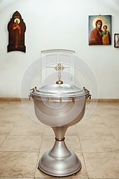 A silvery church font, decorated with gold elements