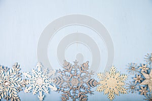 Silvery snowflakes on a wooden background.