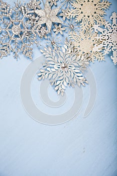 Silvery snowflakes on a wooden background.