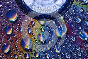 Silvery water drops on abstract CD surface with rainbow colors background asset