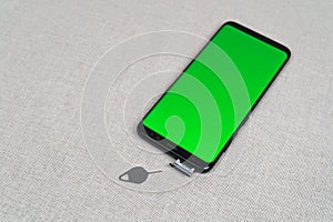 Sim card tray and smartphone with green screen and eject tool