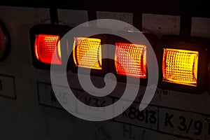 Simple abstract old retro industrial heavy duty equipment indicator lights illuminated controls, indicators in a dark room, old