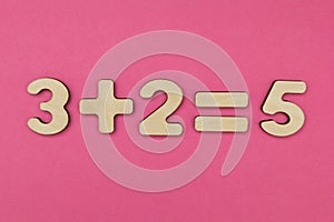 Simple arithmetic for children. Three plus two - equal to five on a bright pink background