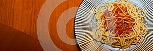 Simple bachelor dinner of spaghetti with tomato sauce, spaghetti neapolitana on a wooden platter with lots of copy space