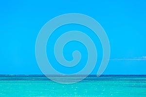 Simple background of turquoise blue sea water and clear blue sky