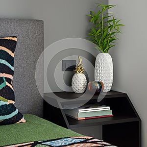 Simple bedside table with stylish decorations, close-up
