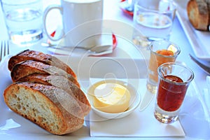 Simple breakfast with bread, butter, jams and coffee served on table