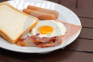 Simple breakfast. Toast bread, fried egg, sausage, ham and bacon