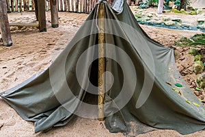 Simple camping tent made out of a wooden pole and a canvas, basic survival equipment
