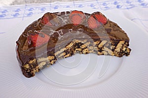 Simple chocolate cake, pie or flan made from quality chocolate english style bisquits and fresh raw strawberries