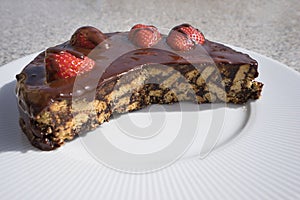 Simple chocolate cake, pie or flan made from quality chocolate english style bisquits and fresh raw strawberries