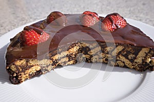 Simple chocolate cake, pie or flan made from quality chocolate english style bisquits and fresh raw strawberries