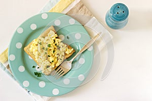 Simple classic breakfast of bread toast and scrambled eggs with parsley.
