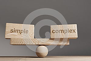 Simple and complex balance concept. Wooden cube block with word Simple and complex on seesaw. Life style concept